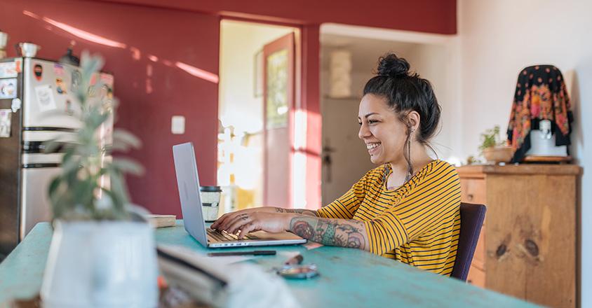 woman with tattoos sitting at computer