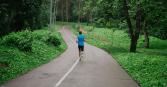 Man running on paved running track in woods