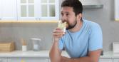 man drinking glass of water with lemon slices